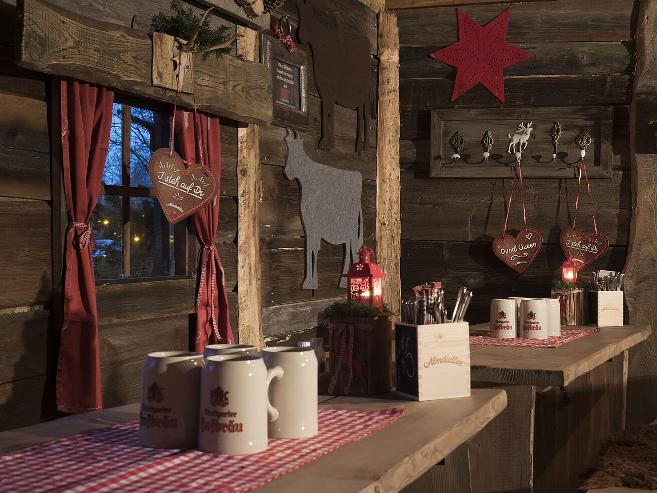 Wooden wall decorated with felt cows, heart cookies and candle lanterns at Maritim Alm Stuttgart
