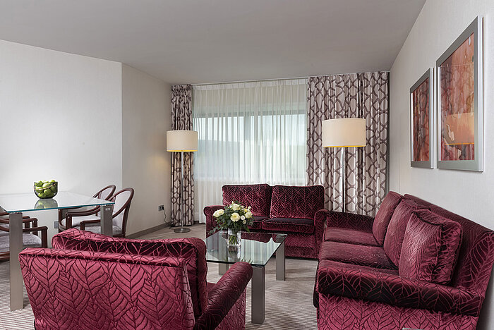 Suite familiar luminosa y espaciosa en el Hotel Maritim Bonn con muebles modernos y área de descanso acogedora.