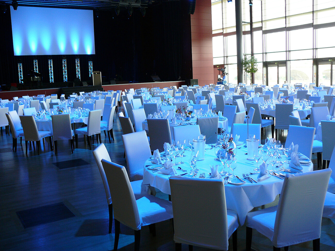 Sala de eventos con iluminación ambiental en el Maritim Hotel Dresden con mesas elegantemente dispuestas.
