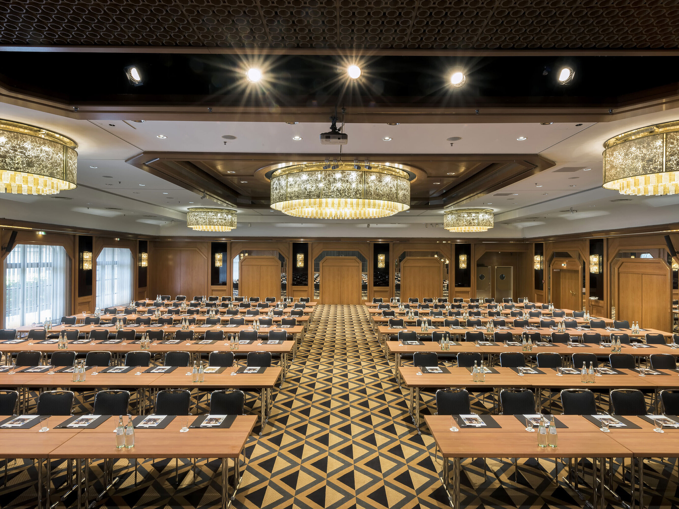 Salle de conférence élégante avec scène, lustres et sièges modernes au Maritim Hotel Königswinter.