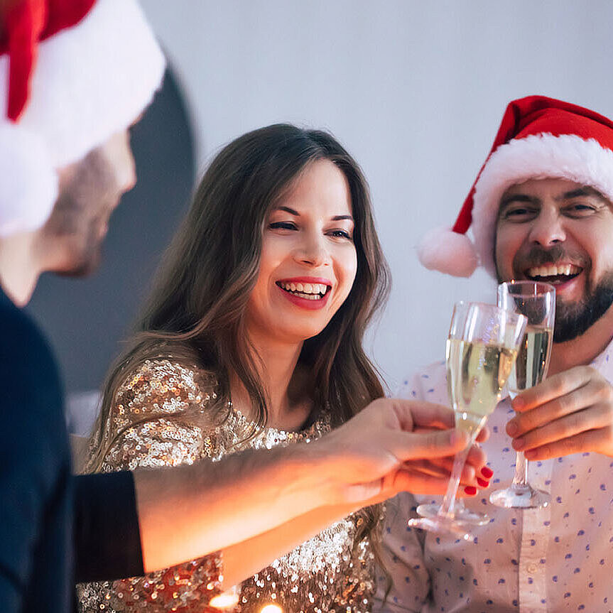 © Maksym Provozniuk - Adobestock.com Joyful Christmas celebration with friends, champagne and festive dinner table