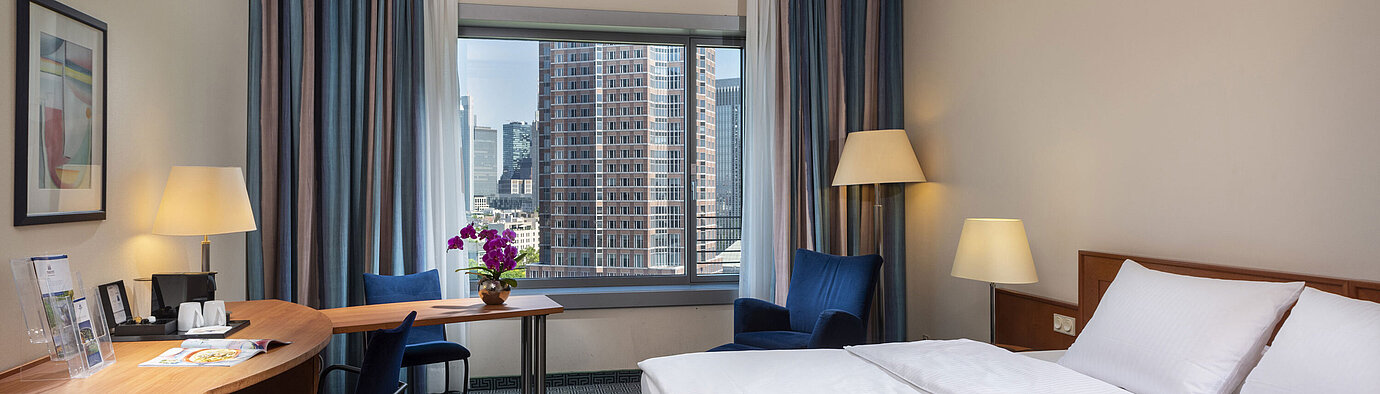 Superior room at Maritim Hotel Frankfurt with a double bed, desk, and view of the Frankfurt skyline.
