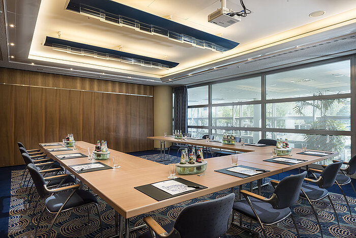 Pequeña sala de reuniones en el Maritim Hotel Frankfurt con disposición en U, luz natural y tecnología moderna para reuniones