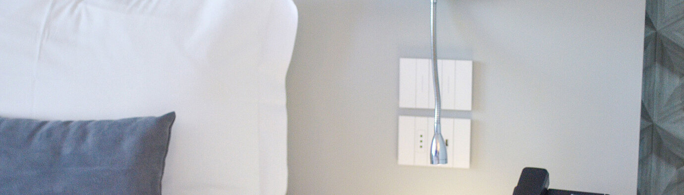 Close-up of nightstand at Maritim Resort Calabria with phone and LED reading lamp