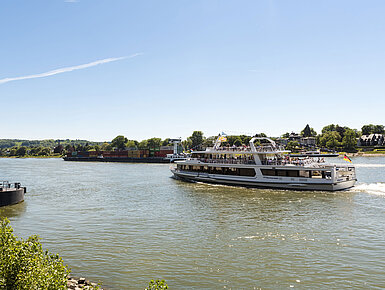 A sightseeing ship on the Rhine near Königswinter with a view of the picturesque landscape.