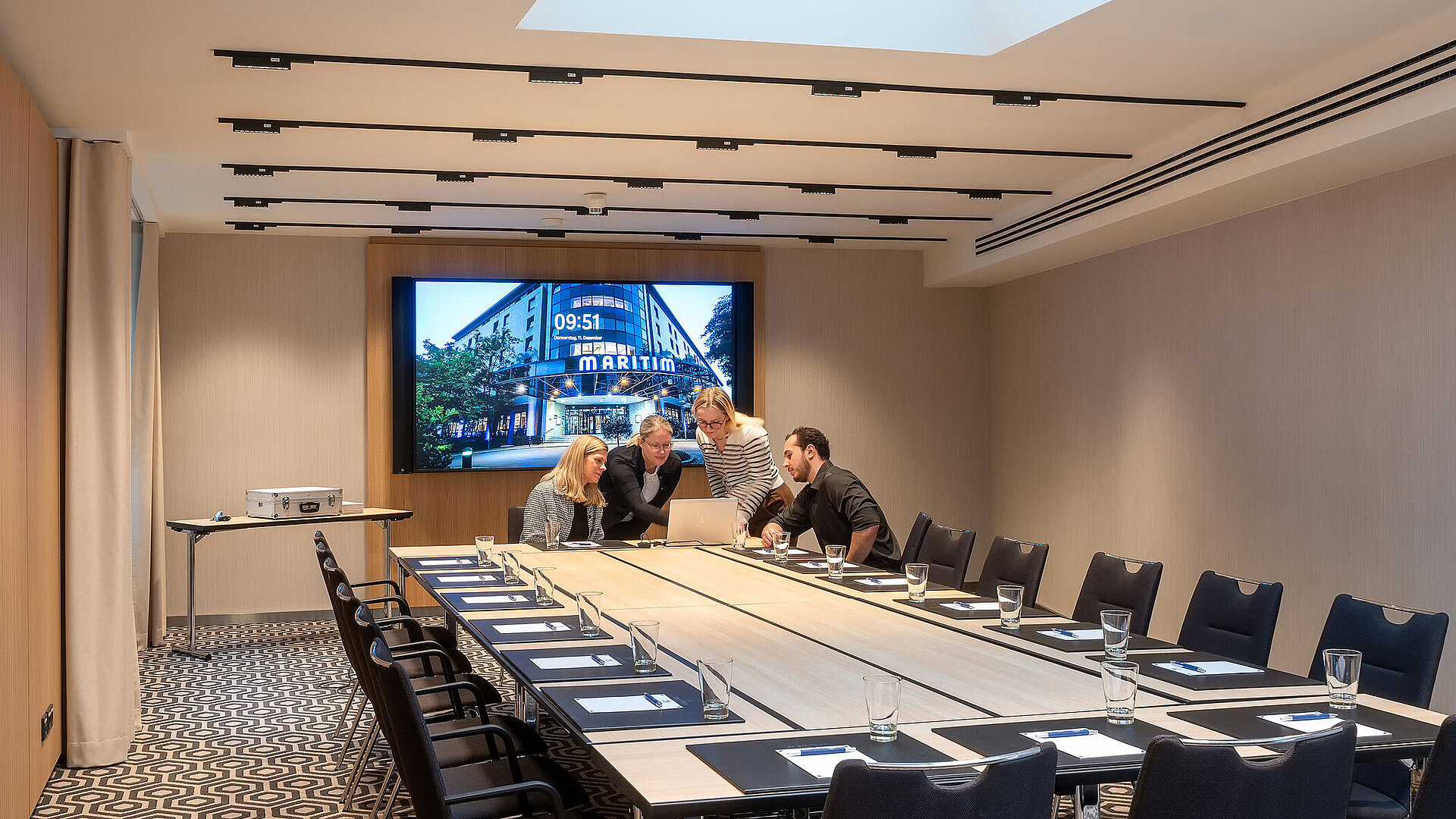 Meeting room 2 with conference table, modern technology, screen and a professional meeting atmosphere.