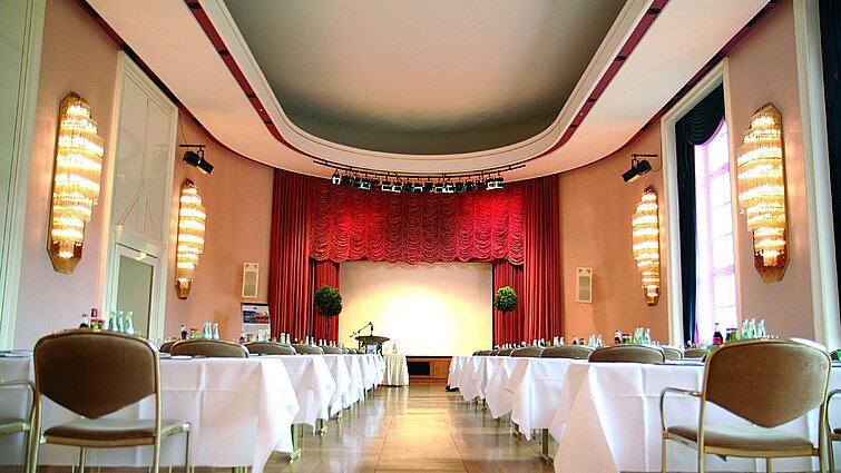 Conference room at Maritim Hotel Bad Wildungen with stage, red curtains and daylight