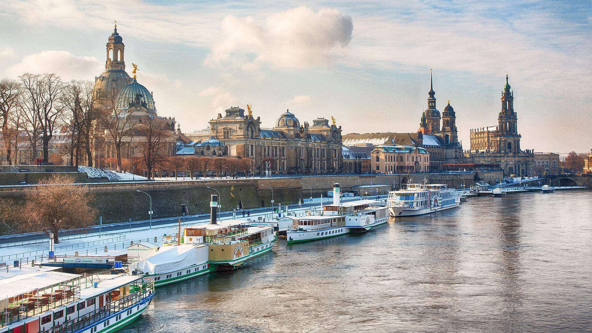 Dresden’s old town with Frauenkirche and Semperoper along the River Elbe in a winter panorama.