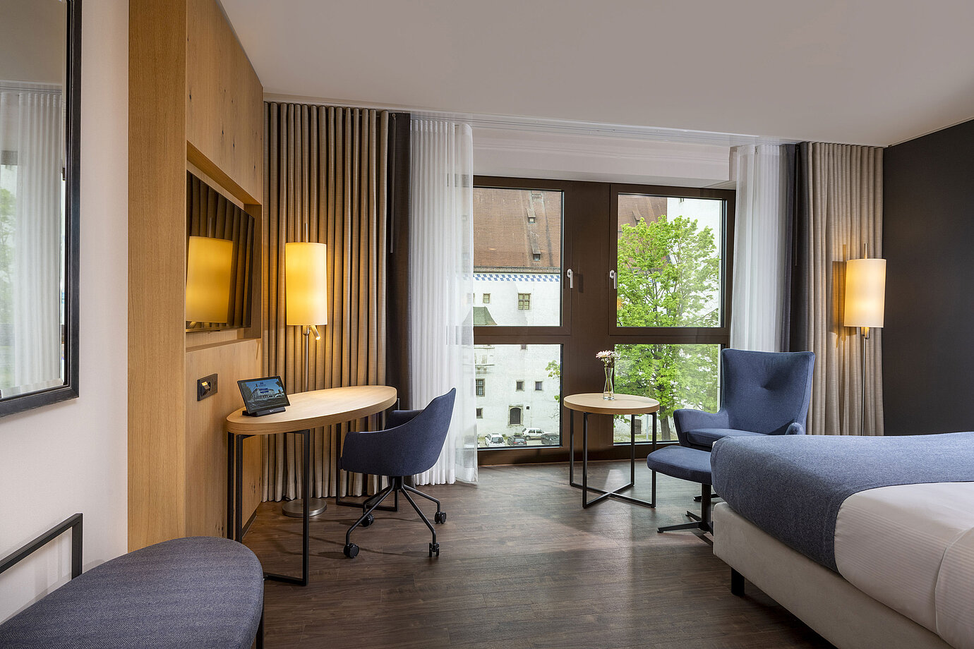 Modernly furnished hotel room at Maritim Hotel Ingolstadt with a desk and city view.