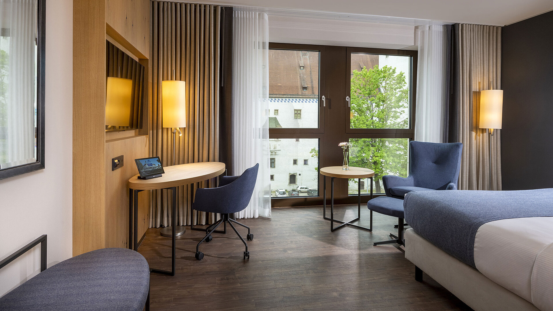 Chambre Classic Chambre moderne de l’hôtel Maritim Ingolstadt avec bureau et vue sur la ville.