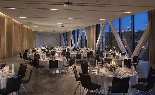 Elegante sala de eventos del Maritim Hotel Würzburg con mesas redondas y vista a la fortaleza