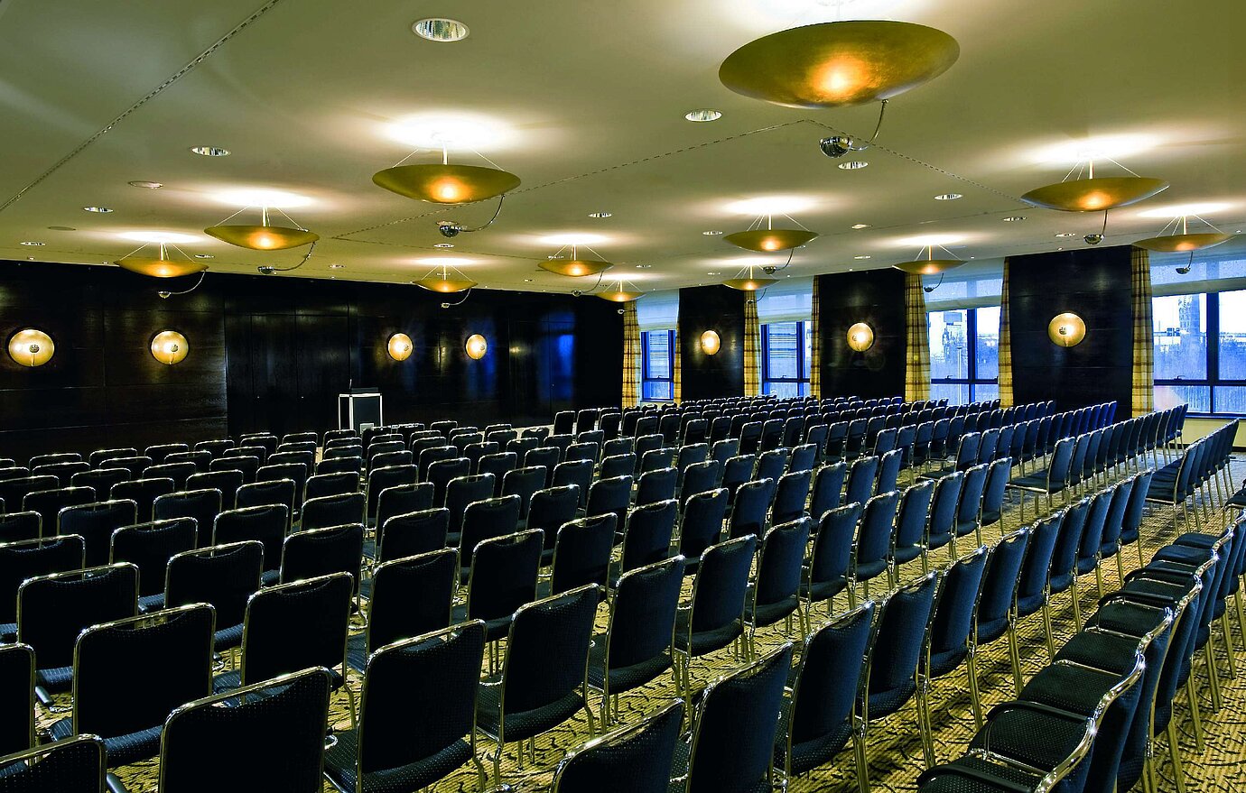 Sala de conferencias en el Maritim Hotel Düsseldorf con iluminación elegante y asientos en fila,ideal para reuniones y eventos