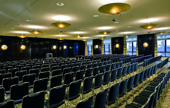 Sala de conferencias en el Maritim Hotel Düsseldorf con iluminación elegante y asientos en fila,ideal para reuniones y eventos