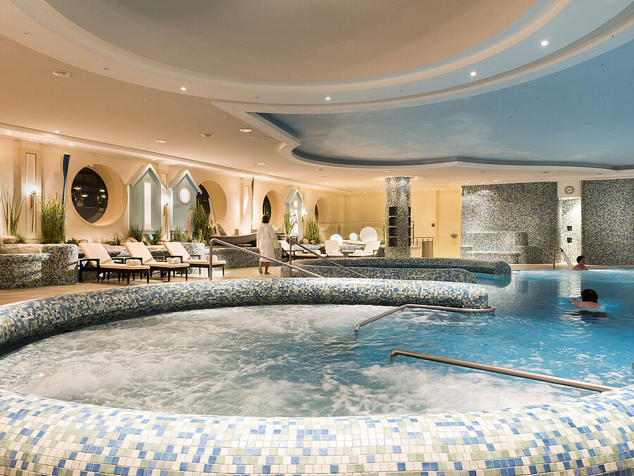 Ampia area benessere con idromassaggio e lettini al Maritim Seehotel Timmendorfer Strand.