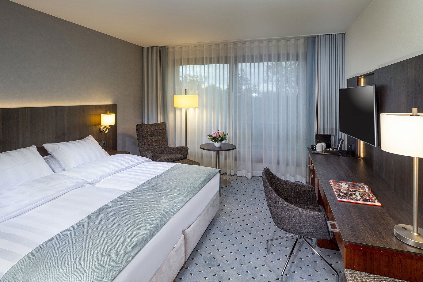 Modern Superior double room at Maritim Hotel Bremen with seating area, desk, and large window for natural light.