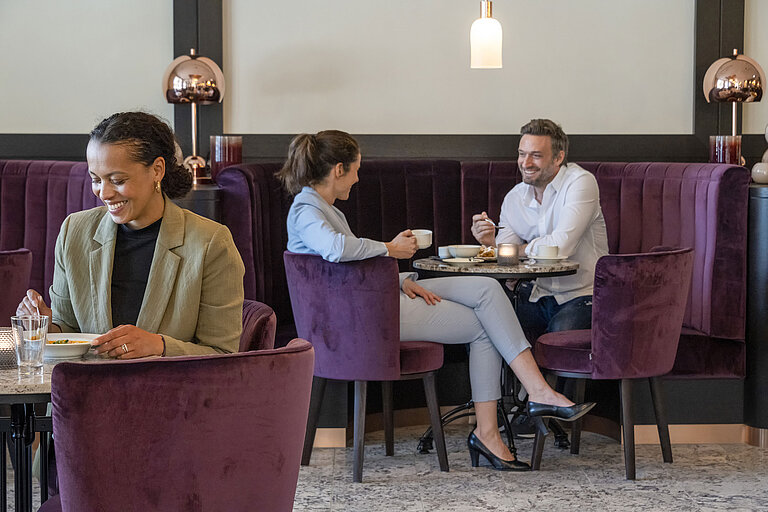 Des clients profitent d'une pause café cosy dans le salon élégant du Maritim Hotel Ingolstadt.