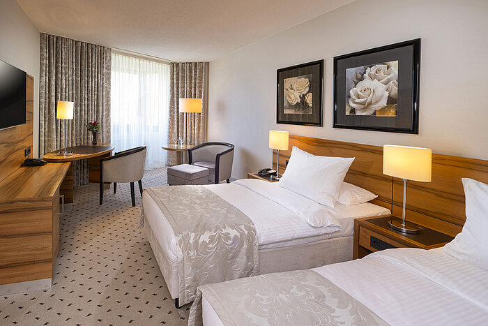 Habitación doble cómoda en el Maritim Hotel Bad Homburg con decoración luminosa y ambiente acogedor.
