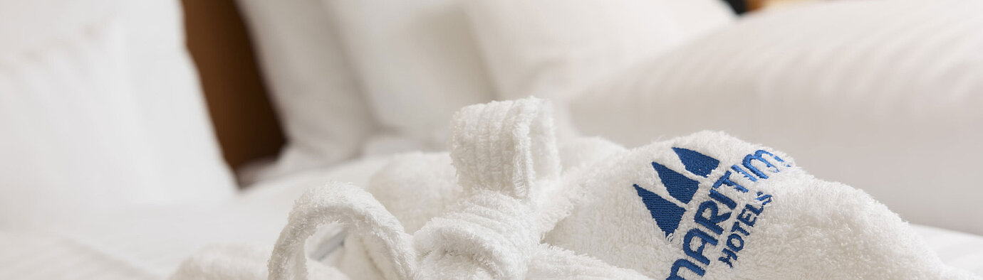 Morbido accappatoio con logo Maritim sul letto al Maritim Hotel Bad Salzuflen