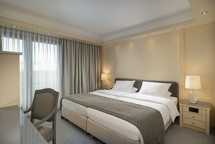 Camera da letto lussuosa in una suite dell’Hotel Maritim Darmstadt con letto matrimoniale e design classico.