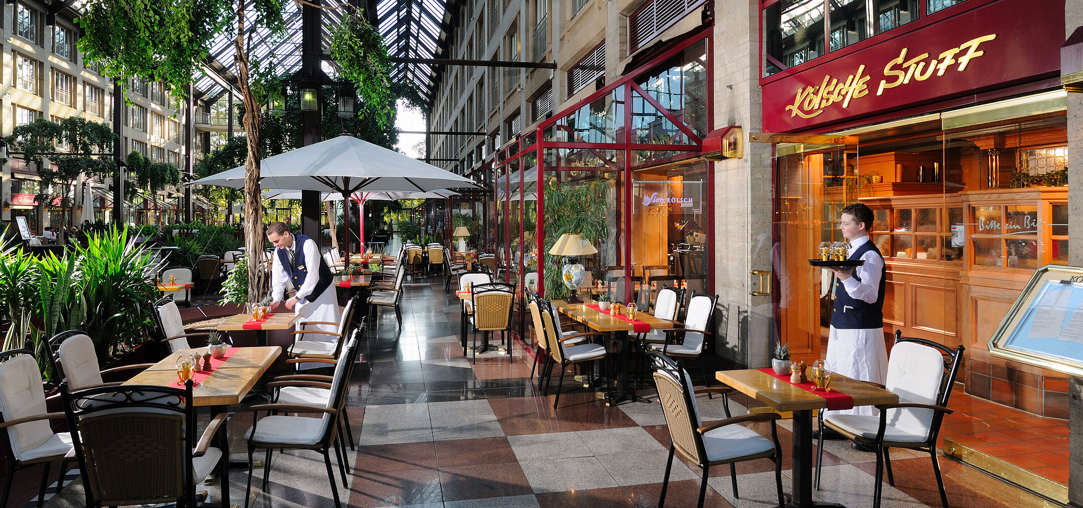 Kölsche Stuff restaurant at Maritim Hotel Cologne, cozy decor with service and outdoor seating under glass roof