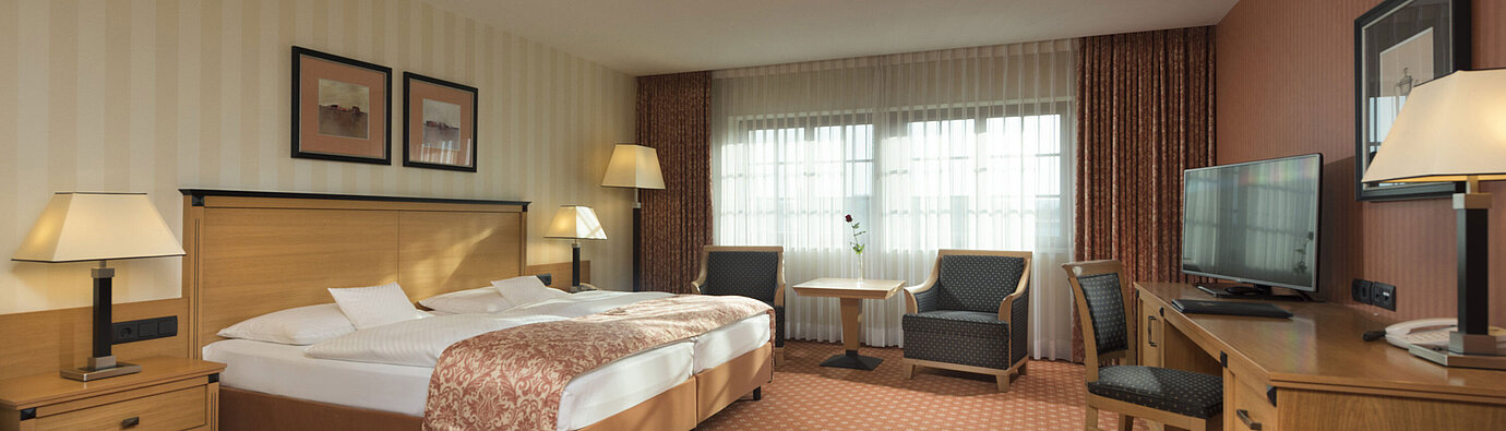 Classic room at Maritim Hotel Dresden with double bed, seating area, and classic decor.