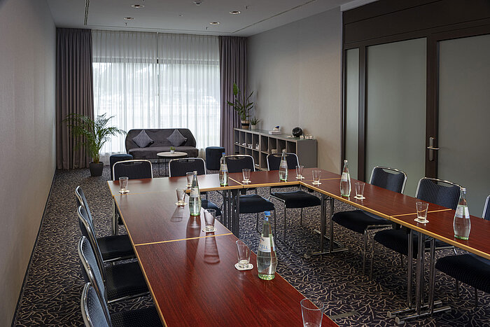 Sala de conferencias moderna en el Maritim Hotel Darmstadt con luz natural, diseño elegante y equipada para reuniones.