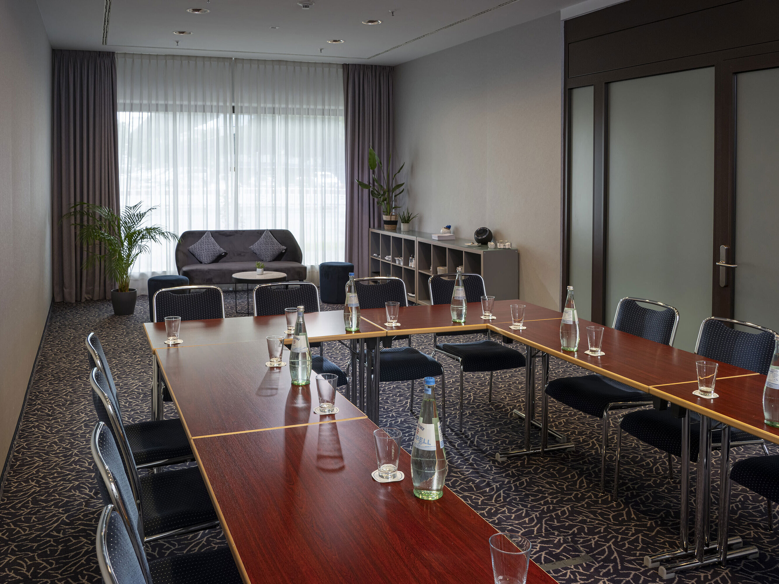 Sala de conferencias moderna en el Maritim Hotel Darmstadt con luz natural, diseño elegante y equipada para reuniones.