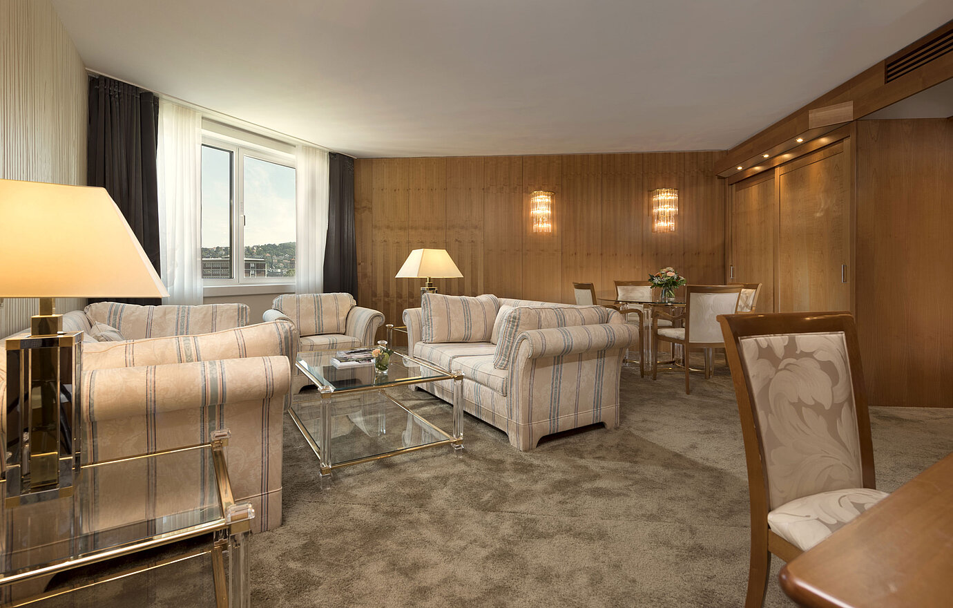 Spacious living room with large window and seating area at Maritim Hotel Stuttgart