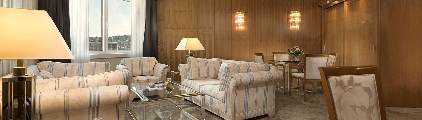 Spacious living room with large window and seating area at Maritim Hotel Stuttgart