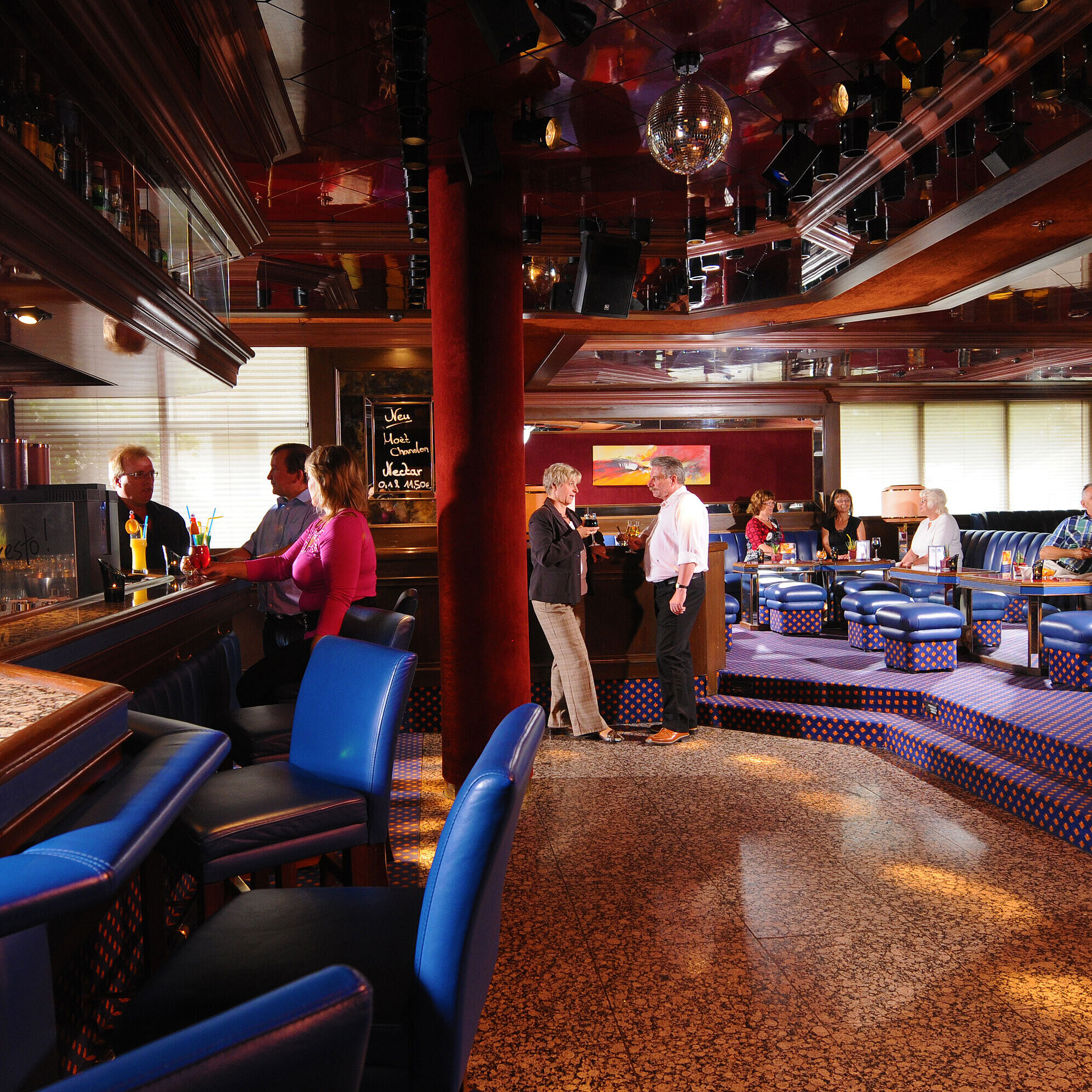 Clientes disfrutando de bebidas en el elegante bar del Maritim Hotel Würzburg