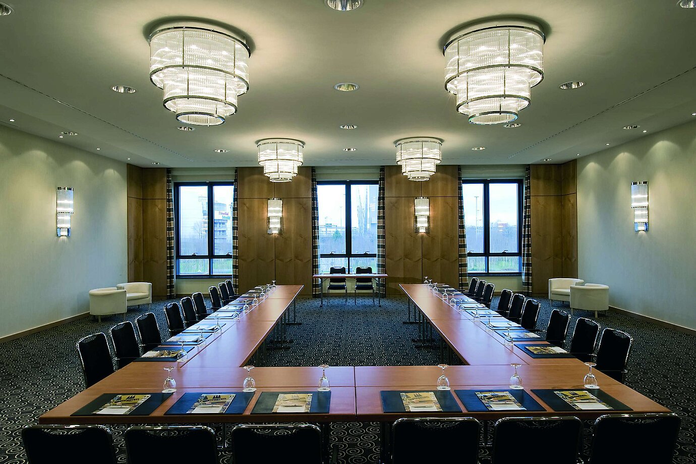 Sala de conferencias moderna en el Maritim Düsseldorf con disposición en forma de U, grandes ventanas e iluminación elegante.