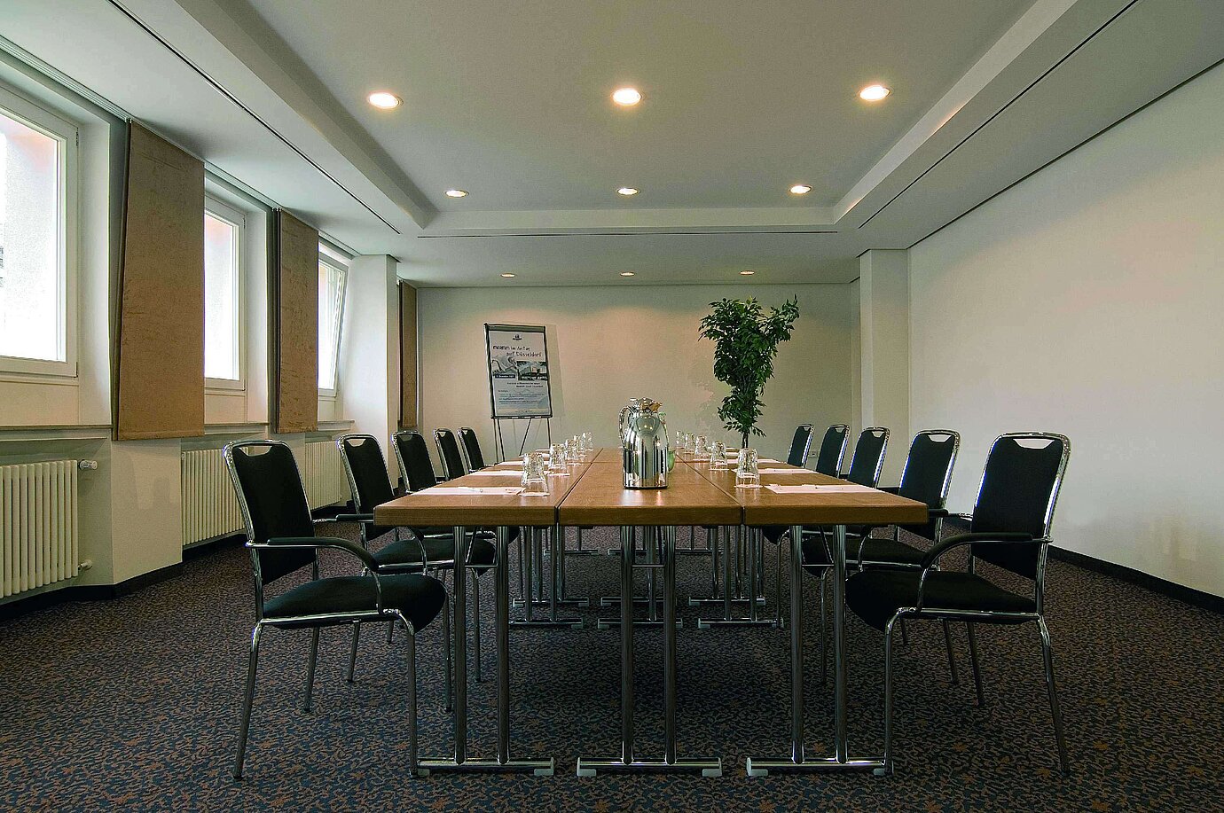 Salle de réunion lumineuse à l'hôtel Maritim Fulda avec équipement moderne et table de conférence.