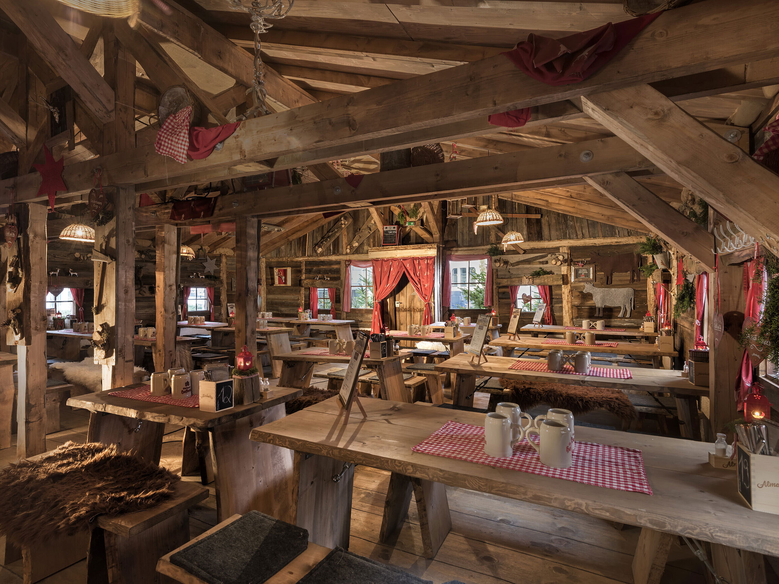 Warm interior with wooden tables, red curtains and rustic decor at Maritim Alm Stuttgart