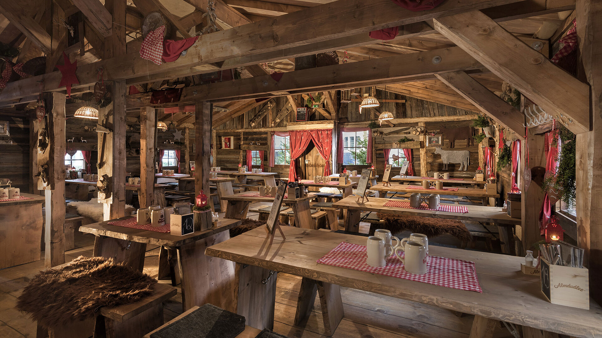 Warm interior with wooden tables, red curtains and rustic decor at Maritim Alm Stuttgart