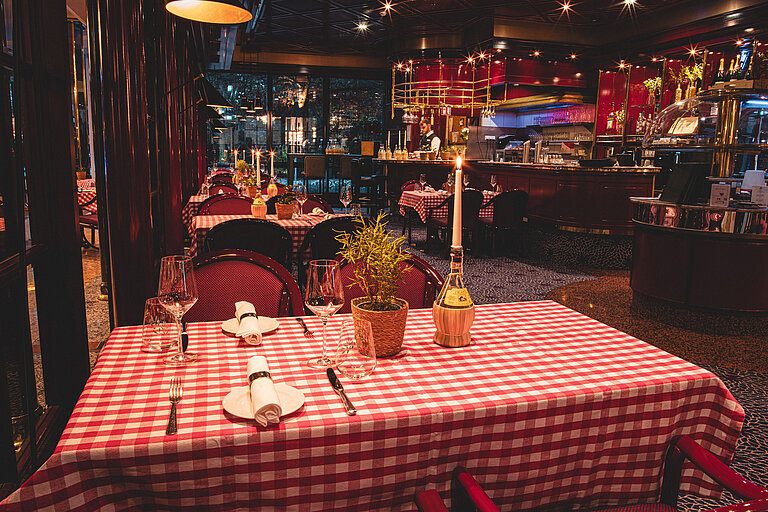Brasserie Restaurant  Cosy restaurant table with candle and red checkered pattern in the evening
