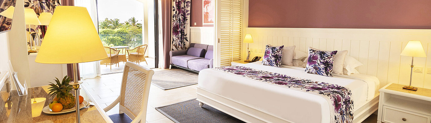 Junior Suite Room with a king-size bed, stylish furniture, and access to the terrace with a sea view