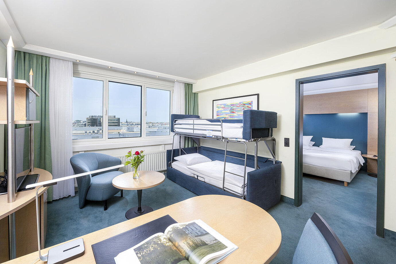 Modern family suite in the Maritim proArte Hotel Berlin with bunk bed, sitting area and separate bedroom.