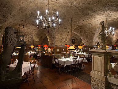 Restaurant historique au Maritim Hotel Fulda avec plafond voûté, lumière des bougies et ambiance rustique.