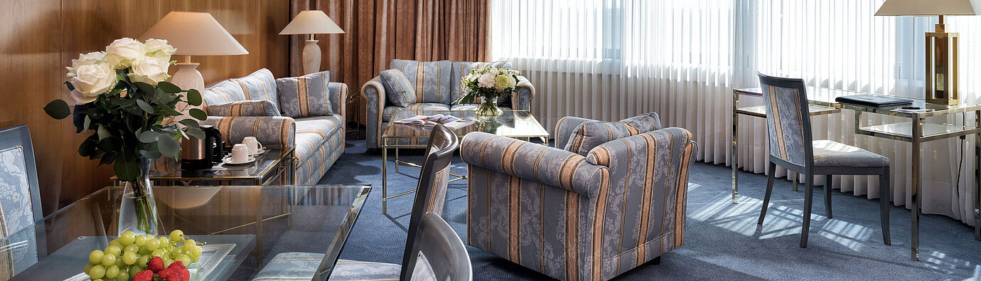 Elegant Master Suite at Maritim Hotel Hannover with classic design, stylish seating, and bright panoramic windows.