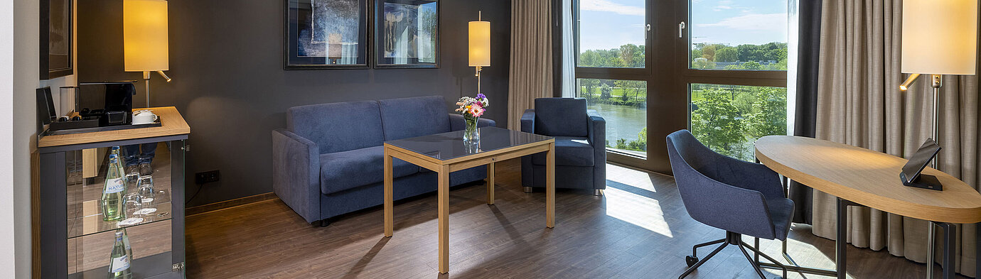 Junior Suite Bright suite with seating area, large window, and nature view at Maritim Hotel Ingolstadt.