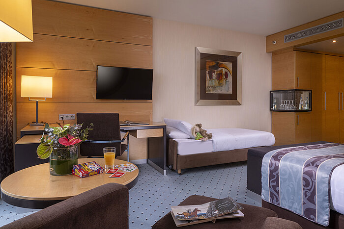 Cómoda habitación familiar en el Maritim Hotel Düsseldorf con diseño moderno y cama adicional para niños.