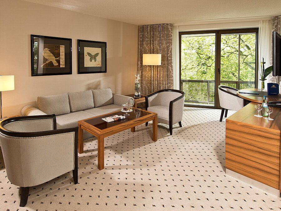 Cozy living area of the suite at Maritim Hotel Bad Homburg with elegant seating and balcony.