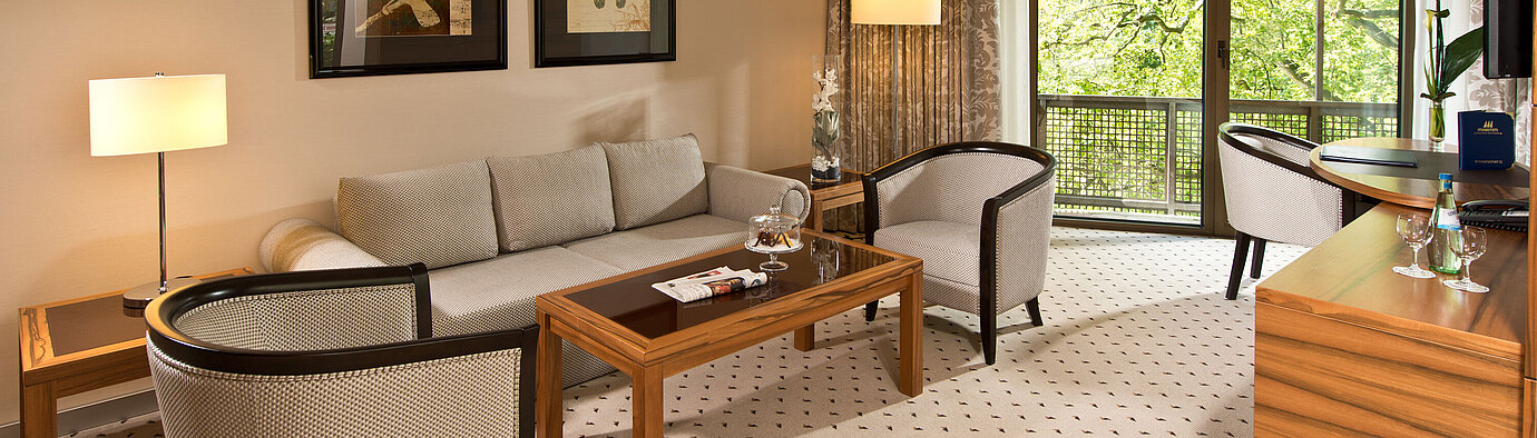 Suite Executive  Área de estar acogedora de la suite en el Hotel Maritim Bad Homburg con zona de asientos elegante y balcón.