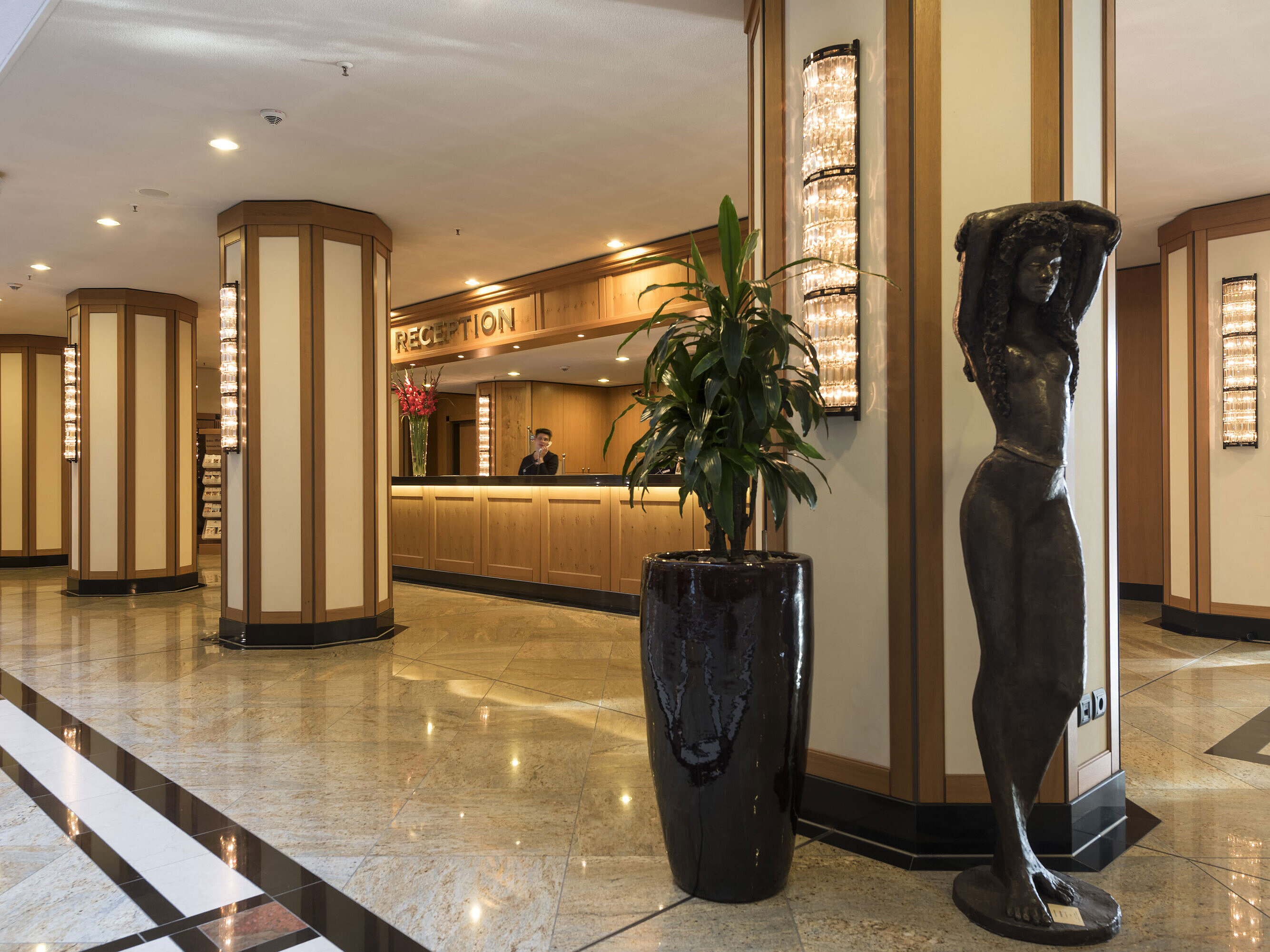 Réception élégante de l'hôtel Maritim de Dresde avec sculpture et éclairage moderne.