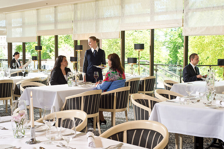 Restaurant lumineux avec vue sur le jardin à l'hôtel Maritim Bad Homburg.