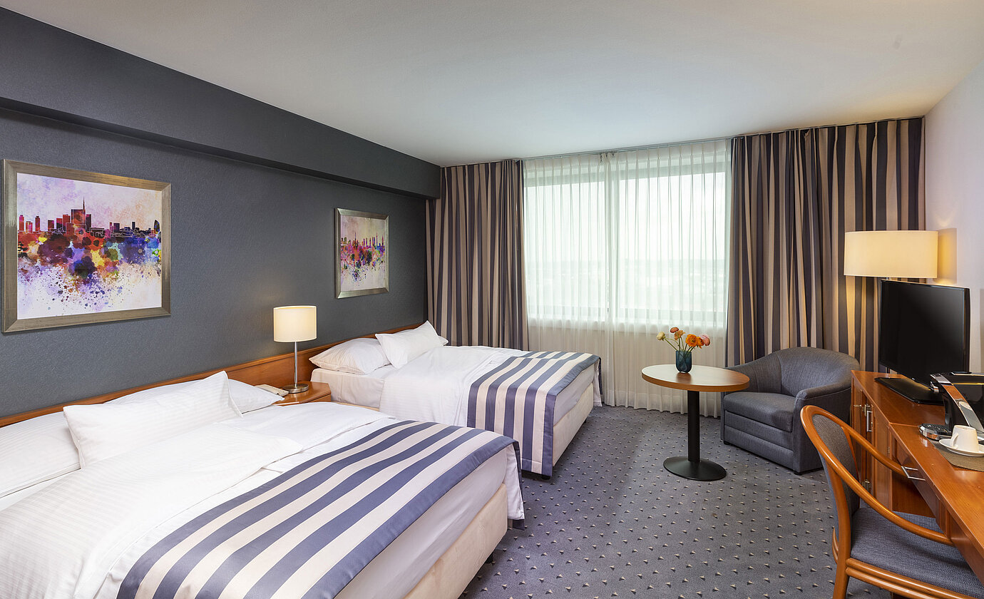 Chambre familiale au Maritim Hotel Ulm avec deux lits simples, TV et coin salon confortable