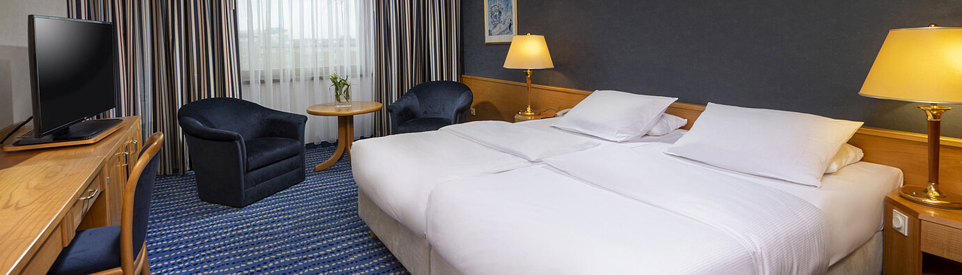 Chambre double confort avec coin salon, bureau et œuvres d'art modernes au mur