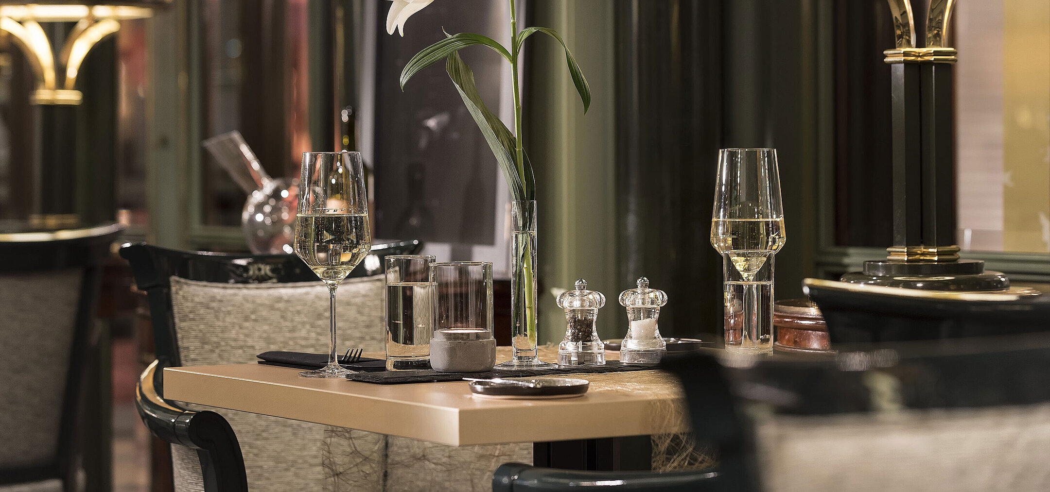 Mesa elegante con flor y copas de vino en el restaurante La Marée, Maritim Hotel Bonn, ideal para una cena elegante.