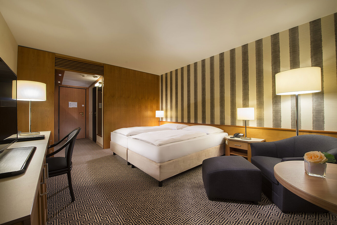 	Bright double room with soft lighting and cosy sitting area at Maritim Hotel Stuttgart