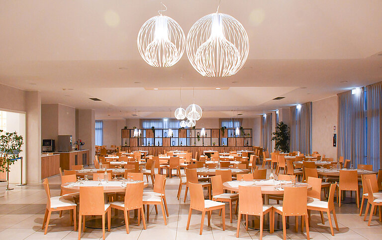 Grande salle à manger au Maritim Resort Calabria avec éclairage élégant et nombreux sièges